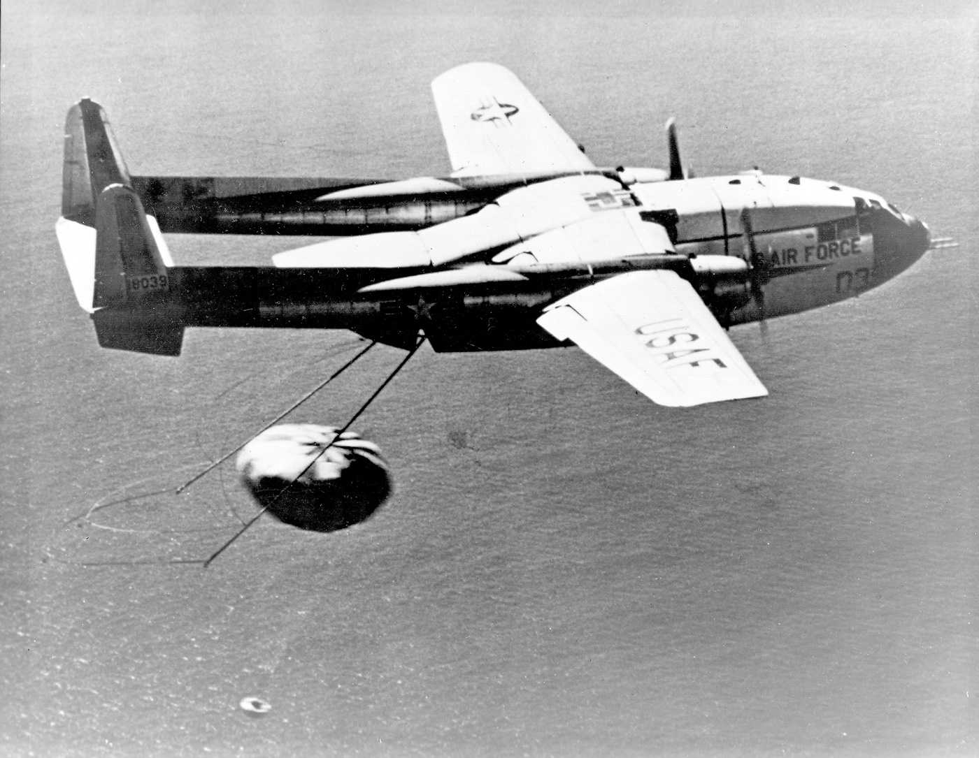 A Fairchild C-119 aircraft recovering a Corona film-return capsule in mid-air, 1960.